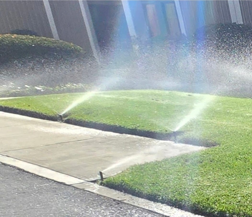 Pop-up sprinkler heads spraying commercial lawn